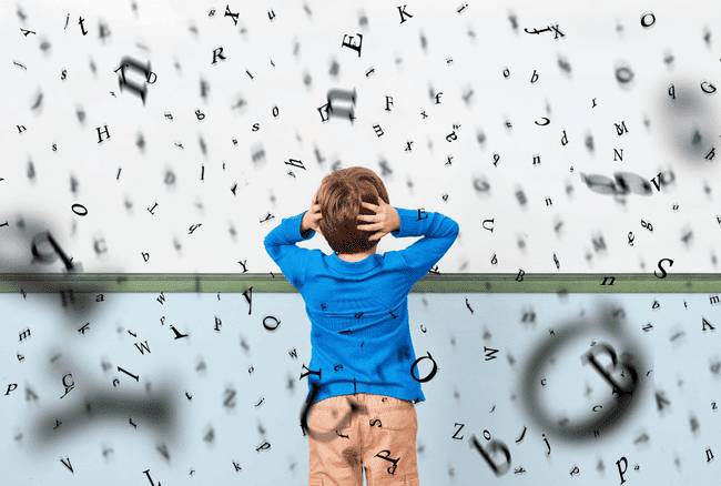 un enfant désemparé devant un mur de lettres
