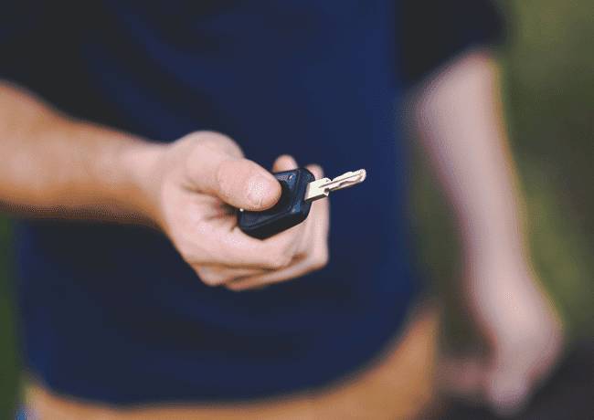 une personne tient une clé de voiture dans sa main